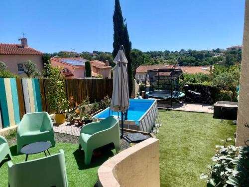 une cour avec un parasol, des chaises et une piscine dans l'établissement Charmante villa familiale avec piscine, à Fréjus