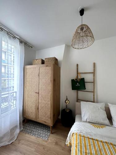 - une chambre avec un lit et une commode à côté d'une fenêtre dans l'établissement Studio parisien au cœur de Paris, à Paris