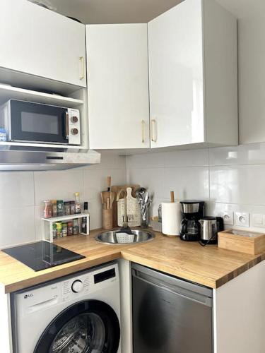 une cuisine avec un lave-linge et un micro-ondes dans l'établissement Studio parisien au cœur de Paris, à Paris