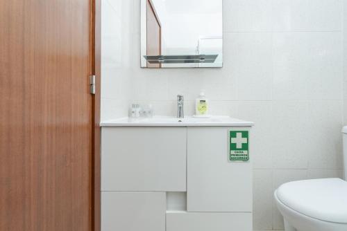 a bathroom with a sink and a toilet and a mirror at Alojamento Local Trigal in Funchal