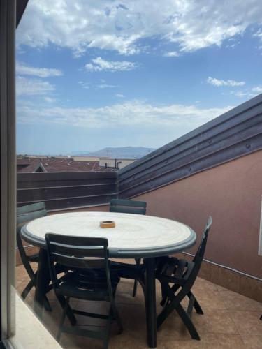 a table and chairs on a balcony with a view at Messina Skyline in Messina