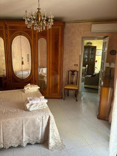 a bedroom with a bed and a chandelier at Appartamento centro storico quartiere San Michele in Sciacca