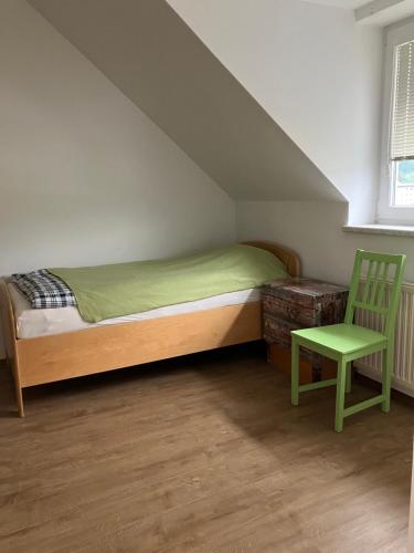 a bedroom with a bed and a green chair at YveBeaRoe in Knittelfeld