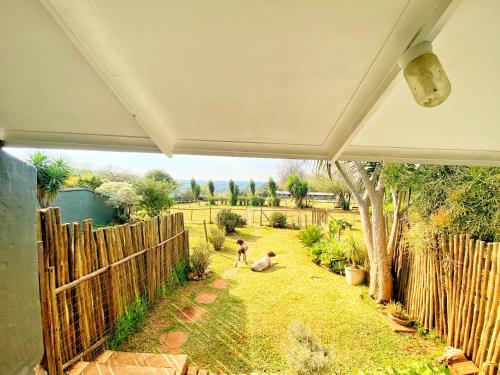 two people standing in a yard next to a fence at Fever Tree Guesthouse in Hillcrest