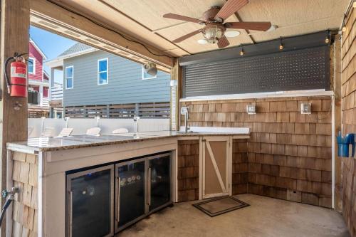 a patio with a bar with a ceiling fan at NH387B Ocracoke Cottage in Nags Head
