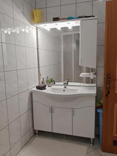 a white bathroom with a sink and a mirror at Apartman Ort in Međugorje