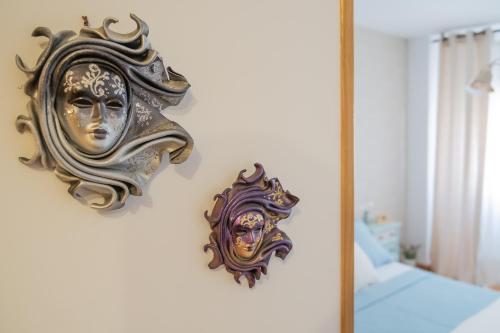 two masks on a wall next to a mirror at Elefantes in Rivas-Vaciamadrid