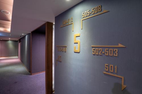 a wall with a clock on the side of a room at CHECK inn Taichung Wenxin Zhongqing in Taichung