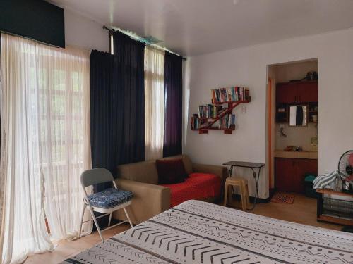 a bedroom with two beds and a living room with a couch at The Lakehouse Studio Tagaytay in Tagaytay