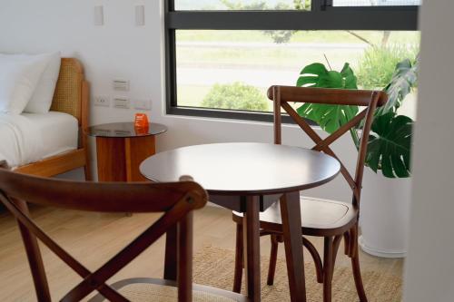 a table and chairs in a living room with a window at No.1899 House in Meinong