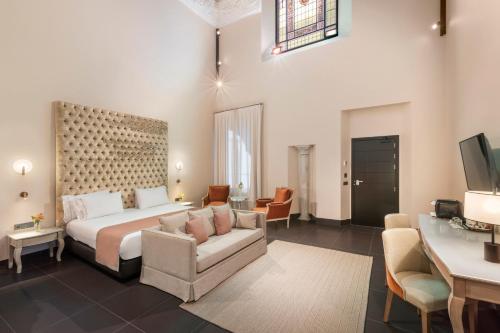 a hotel room with a bed and a living room at Eurostars Sevilla Boutique in Seville