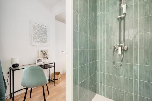 Un baño con ducha con silla y escritorio. en Le Coquet des Trois-Maisons avec parking privatif, en Nancy