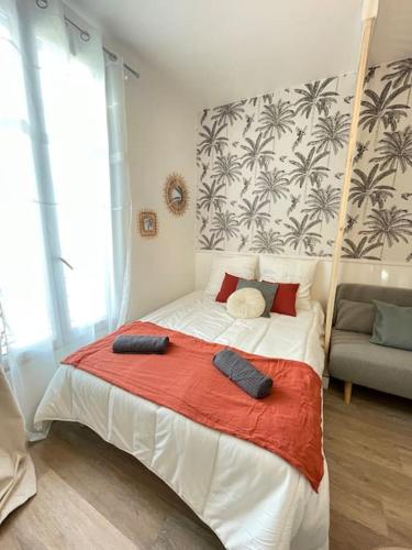 une chambre avec un grand lit avec une couverture rouge dans l'établissement Studio 10min Paris Centre I CDG, à Drancy