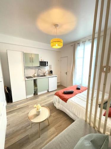 une chambre avec un lit et une table et une cuisine dans l'établissement Studio 10min Paris Centre I CDG, à Drancy