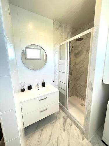 une salle de bain blanche avec un lavabo et une douche dans l'établissement Studio 10min Paris Centre I CDG, à Drancy