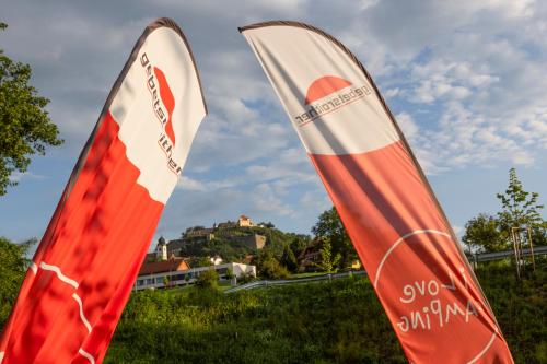 two red and white flags sitting in the grass at Camping Resort Riegersburg in Riegersburg