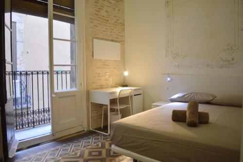 une chambre avec un lit, un bureau et une fenêtre dans l'établissement Barcelona Classic Plaza Real Apartments, à Barcelone