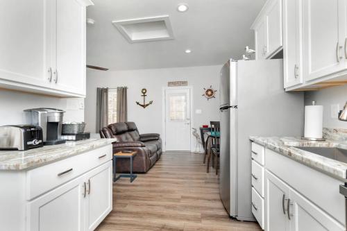 a kitchen with white cabinets and a refrigerator at Tiny Luxury Studio GuestHouse in Deltaville in Deltaville