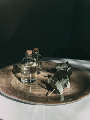 a plate with two glass bottles on a table at La Urumpta Hotel, AKEN MIND in Río Cuarto