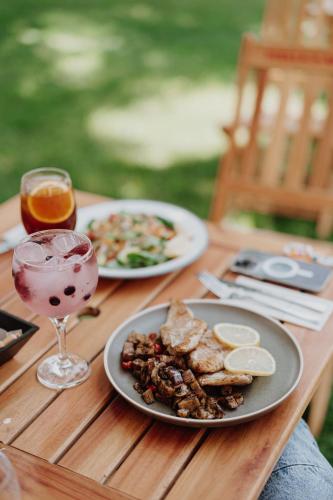 a wooden table with two plates of food and a drink at La Urumpta Hotel, AKEN MIND in Río Cuarto