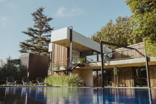 a house with a swimming pool in front of it at La Urumpta Hotel, AKEN MIND in Río Cuarto