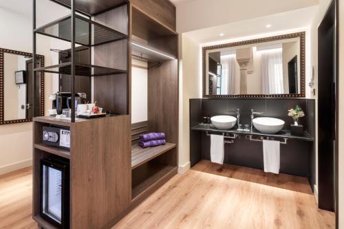 a bathroom with two sinks and a mirror at Eurostars Sevilla Boutique in Seville