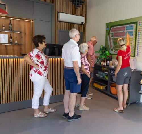 a group of people standing at a cash register at Camping Resort Riegersburg in Riegersburg