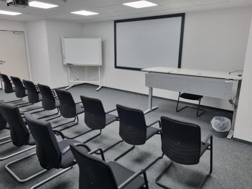 an empty room with chairs and a whiteboard in it at Aparthotel AVANGARD Living in Forchheim