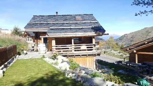 a house with a slate roof and a yard at Charmant chalet unique de montagne Nendaz in Nendaz