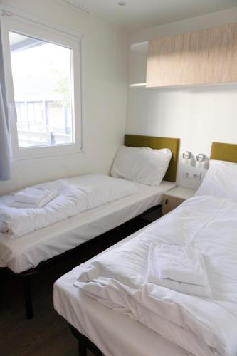 two beds in a room with a window at Camping Resort Riegersburg in Riegersburg