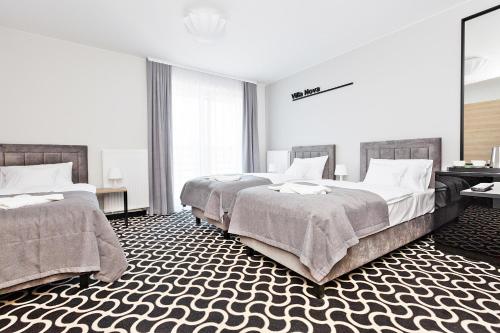 a bedroom with two beds and a large window at Villa Nova in Białystok