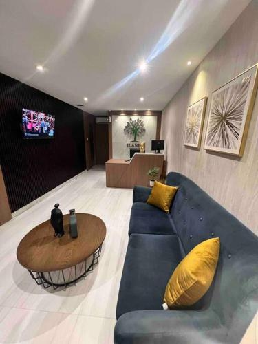 a living room with a blue couch and a table at Novapark Urdesa in Guayaquil