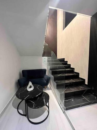 a room with a staircase with a chair and a mirror at Novapark Urdesa in Guayaquil