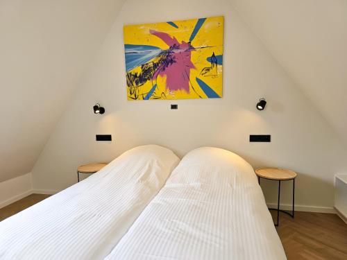 a white bed in a room with a painting on the wall at Vakantiehuis DO52 centrum Domburg in Domburg