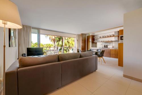uma sala de estar com um sofá marrom e uma cozinha em Herdade dos Salgados na Guia