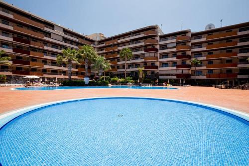 a large swimming pool in front of a large building at Sea Paradise - Balcon de los Gigantes in Puerto de Santiago
