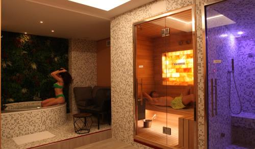a bathroom with a shower with two people laying in a tub at The Hive Hotel in Rome