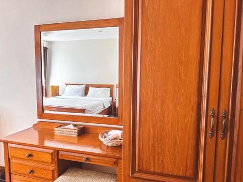 a bedroom with a mirror and a wooden cabinet at Chez Moi Bangkok Private Executive Residence Sukhumvit 26 in Khlong Toei