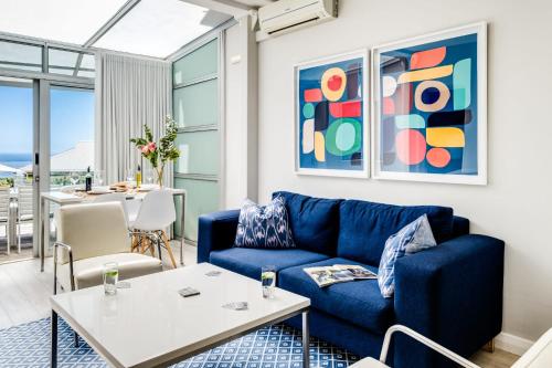 a living room with a blue couch and a table at Sea Escape in Cape Town