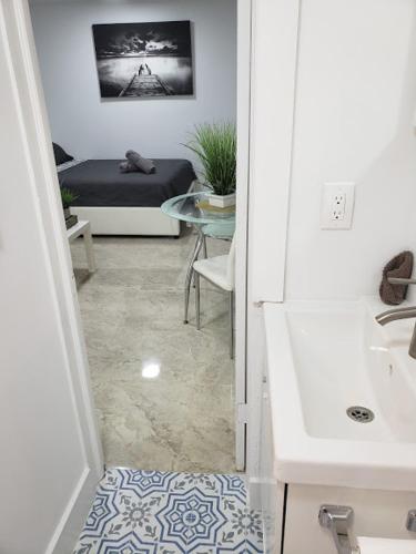 a hallway with a sink and a bed in a room at Apts with Backyard Near Fort Lauderdale Beach, Nightlife, Cruise Port, Airport in Fort Lauderdale
