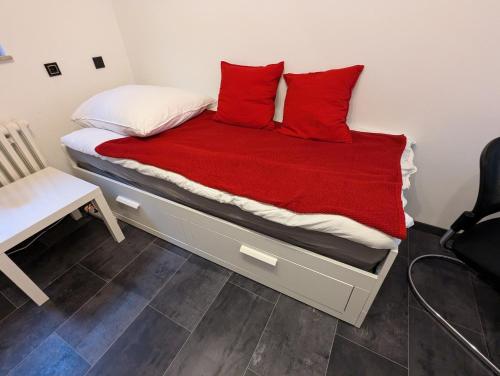 a bed with two red pillows on top of it at Budget Zimmer im Siebengebirge in Königswinter