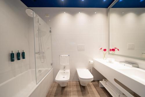 a bathroom with a sink and a toilet and a shower at Hilton Sorrento Palace in Sorrento