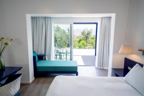 a hotel room with a bed and a couch and a patio at Hilton Sorrento Palace in Sorrento