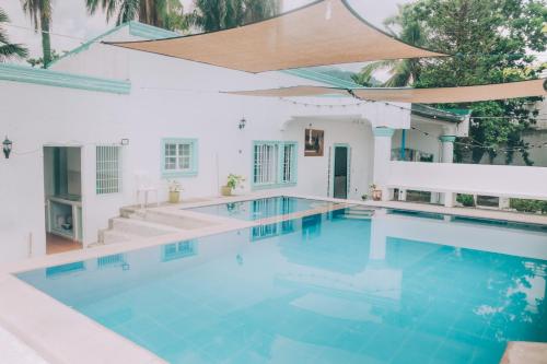 a swimming pool in a house with blue water at Hera Maria Hotspring Resort in Calamba