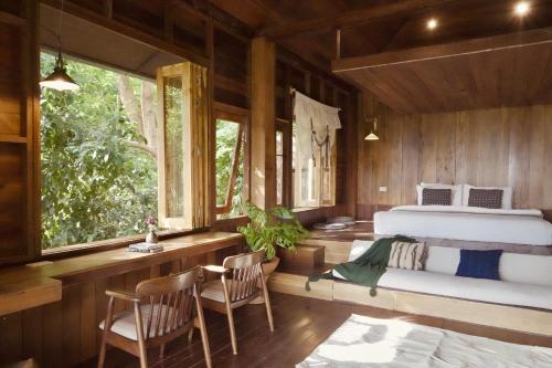 a bedroom with a bed and a table and chairs at ทโล้ โฮมสเตย์ เชียงใหม่ | Taloh Homestay Chiangmai in Mae On