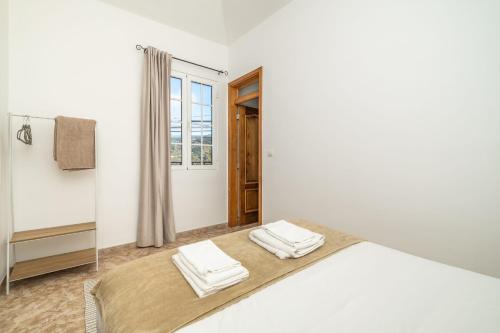 Un dormitorio blanco con una cama y un espejo. en Sunset House, en Ribeira Brava