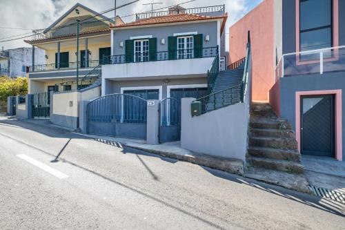 a house with a gate and stairs on a street at Sunset House in Ribeira Brava
