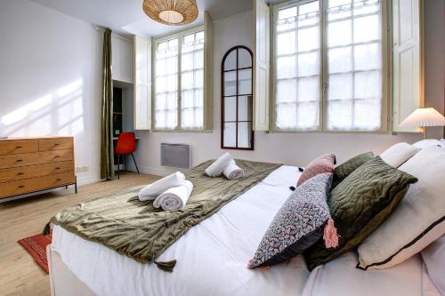 Cette chambre comprend un grand lit et des fenêtres. dans l'établissement OIQIA • Harmonie, à Périgueux