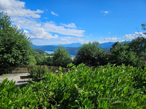 a bench in a garden with mountains in the background at Haus am Hügel in Millstatt