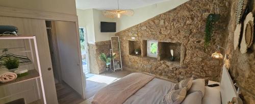 a room with a stone wall with a bed in it at Casadeira de Mucha in Camariñas
